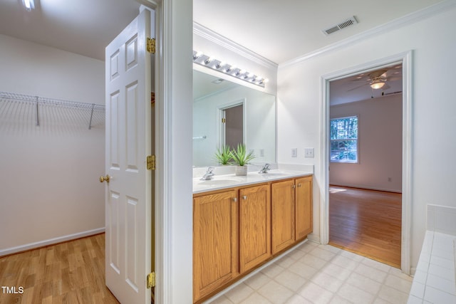 2304 Folger St, Raleigh, NC 27604 - full bath featuring double vanity, wood finished floors, ornamental molding, a ceiling fan, and a walk in closet