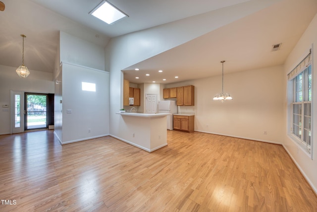 2304 Folger St, Raleigh, NC 27604 - kitchen with freestanding refrigerator, open floor plan, a peninsula, high vaulted ceiling, and recessed lighting