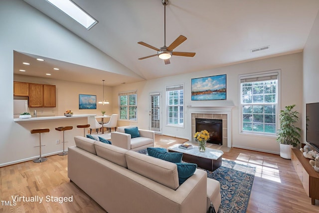2304 Folger St, Raleigh, NC 27604 - living area with lofted ceiling, a tiled fireplace, light wood finished floors, ceiling fan, and recessed lighting