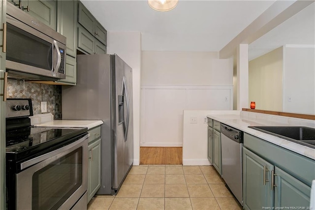 1828 Notre Dame Pl, Fayetteville, NC 28304 - kitchen with appliances with stainless steel finishes, light countertops, backsplash, and light tile patterned floors
