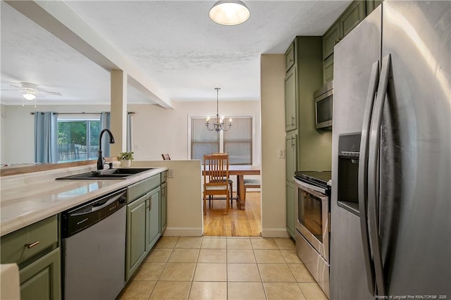 1828 Notre Dame Pl, Fayetteville, NC 28304 - kitchen featuring appliances with stainless steel finishes, green cabinets, light tile patterned floors, light countertops, and a chandelier