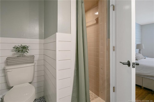 1828 Notre Dame Pl, Fayetteville, NC 28304 - ensuite bathroom featuring a shower stall, a wainscoted wall, wood finished floors, and tile walls