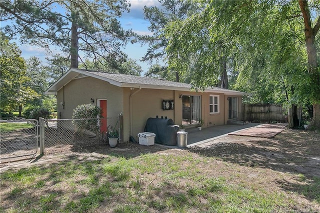 1828 Notre Dame Pl, Fayetteville, NC 28304 - back of house featuring stucco siding, a patio, and a gate