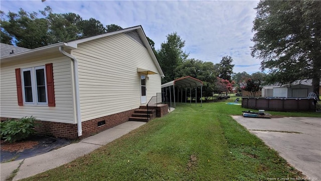 2508 N Roberts Ave N, Lumberton, NC 28358 - view of side of home with a detached carport, crawl space, a lawn, and an outdoor pool