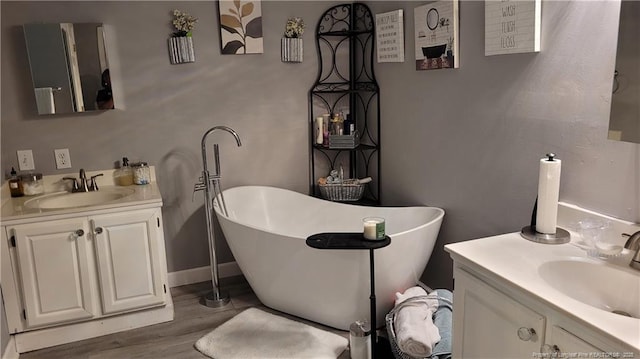 2508 N Roberts Ave N, Lumberton, NC 28358 - full bathroom featuring two vanities, a freestanding tub, and wood finished floors