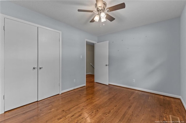 521 Fawn Ct, Fayetteville, NC 28303 - unfurnished bedroom with wood finished floors, a closet, and a ceiling fan