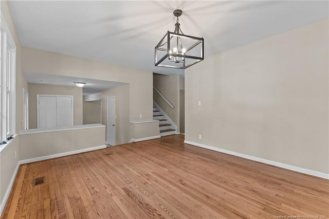 521 Fawn Ct, Fayetteville, NC 28303 - unfurnished living room featuring light wood-style flooring, a chandelier, and stairway