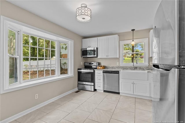 521 Fawn Ct, Fayetteville, NC 28303 - kitchen featuring appliances with stainless steel finishes, white cabinetry, light stone countertops, and light tile patterned floors