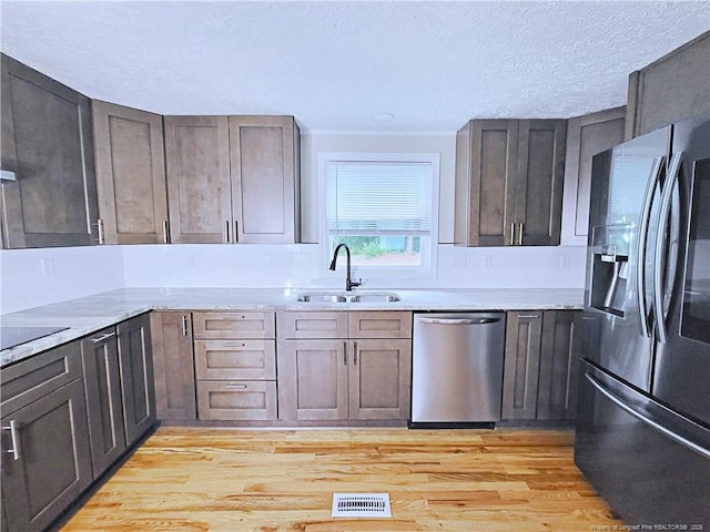 7246 Faircloth Bridge Rd, Stedman, NC 28391 - kitchen with stainless steel appliances, light wood finished floors, crown molding, and a textured ceiling