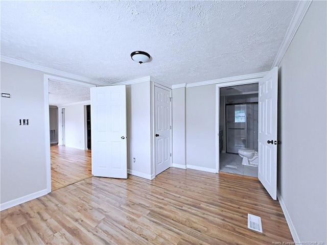 7246 Faircloth Bridge Rd, Stedman, NC 28391 - unfurnished bedroom with a textured ceiling, light wood-style flooring, crown molding, and connected bathroom