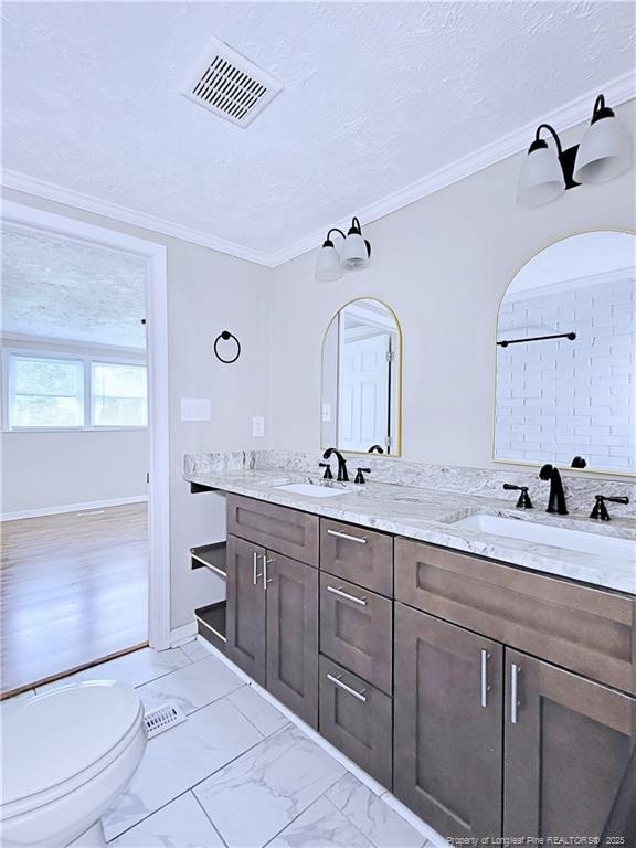 7246 Faircloth Bridge Rd, Stedman, NC 28391 - bathroom with double vanity, marble look tiles, and ornamental molding