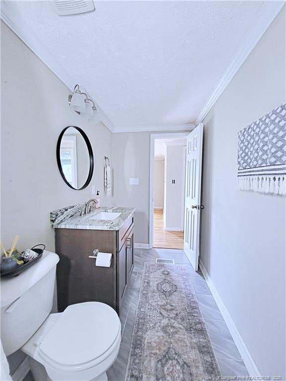 7246 Faircloth Bridge Rd, Stedman, NC 28391 - bathroom featuring vanity, a textured ceiling, crown molding, and wood finished floors