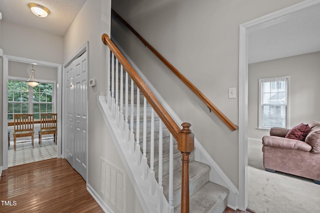 108 Tarlow Ct, Cary, NC 27513 - stairway featuring wood finished floors and a textured ceiling