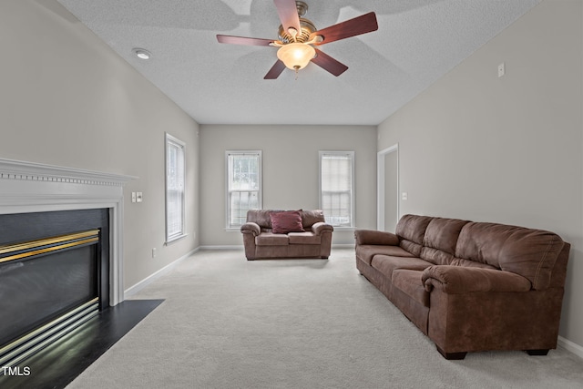 108 Tarlow Ct, Cary, NC 27513 - carpeted living area featuring a ceiling fan, a textured ceiling, and a fireplace with flush hearth