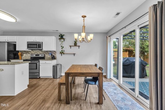 2127 Rivergrass Ct, Raleigh, NC 27610 - dining area featuring light wood-style floors and a chandelier