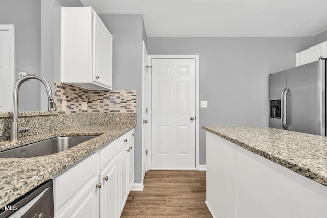 2127 Rivergrass Ct, Raleigh, NC 27610 - kitchen with stainless steel fridge with ice dispenser, wood finished floors, dishwashing machine, white cabinets, and light stone counters