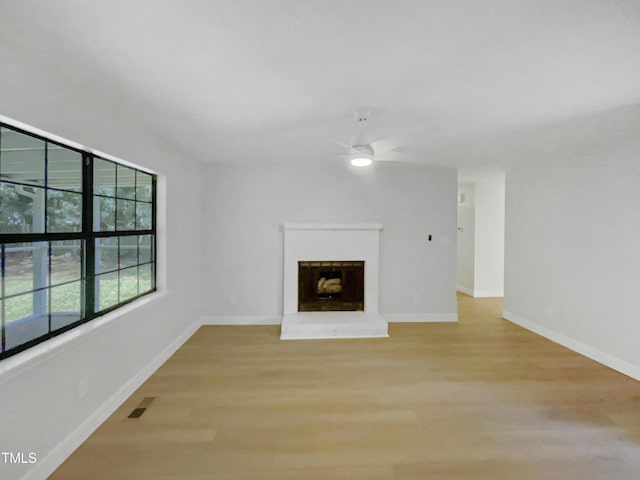 11 Sweetbay Ct, Durham, NC 27704 - unfurnished living room featuring ceiling fan, light wood-style flooring, and a fireplace with raised hearth