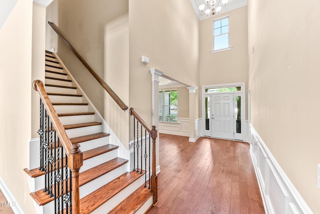 428 Holsten Bank Way, Cary, NC 27519 - foyer featuring a decorative wall, wood-type flooring, a chandelier, a towering ceiling, and a wainscoted wall