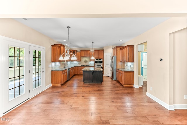 428 Holsten Bank Way, Cary, NC 27519 - kitchen with appliances with stainless steel finishes, brown cabinets, light wood-style flooring, tasteful backsplash, and recessed lighting