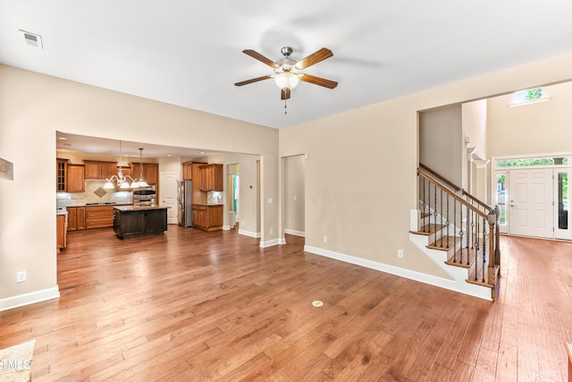 428 Holsten Bank Way, Cary, NC 27519 - unfurnished living room with ceiling fan, stairs, and light wood-type flooring