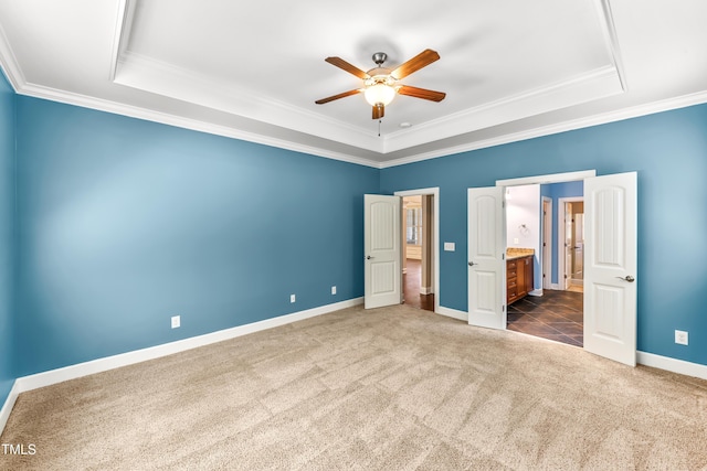 428 Holsten Bank Way, Cary, NC 27519 - unfurnished bedroom featuring a tray ceiling, dark colored carpet, crown molding, connected bathroom, and ceiling fan