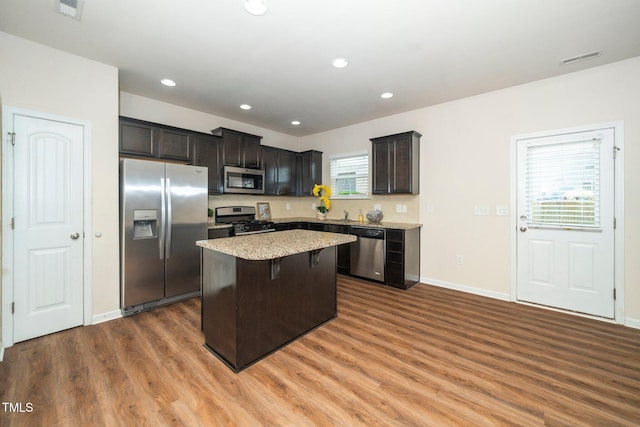 2522 Dalmahoy Ln, Fuquay Varina, NC 27526 - kitchen with stainless steel appliances, wood finished floors, a kitchen island, a breakfast bar area, and recessed lighting