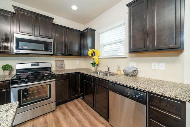 2522 Dalmahoy Ln, Fuquay Varina, NC 27526 - kitchen featuring appliances with stainless steel finishes, light wood-type flooring, decorative backsplash, light stone counters, and recessed lighting