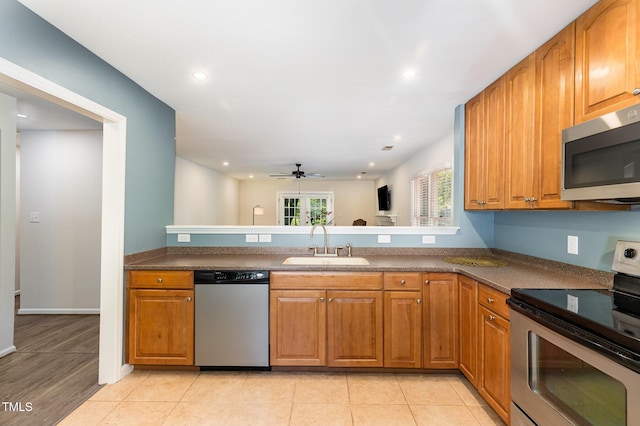 1520 Woodcroft Dr, Raleigh, NC 27609 - kitchen with stainless steel appliances, ceiling fan, brown cabinets, dark countertops, and recessed lighting