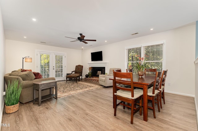 1520 Woodcroft Dr, Raleigh, NC 27609 - dining room featuring a fireplace, light wood-style floors, ceiling fan, recessed lighting, and french doors