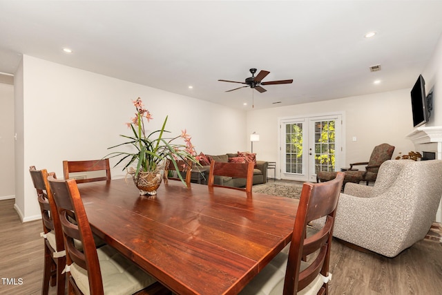 1520 Woodcroft Dr, Raleigh, NC 27609 - dining area featuring wood finished floors, a ceiling fan, recessed lighting, french doors, and a fireplace