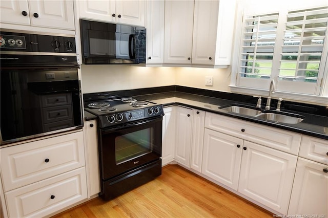 2630 Dartmouth Dr, Fayetteville, NC 28304 - kitchen featuring black appliances, dark countertops, white cabinets, and light wood-style flooring