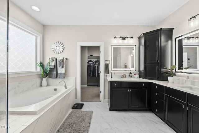 7741 Wilderness Rd, Raleigh, NC 27613 - full bath with double vanity, a bath, marble look tiles, and a spacious closet