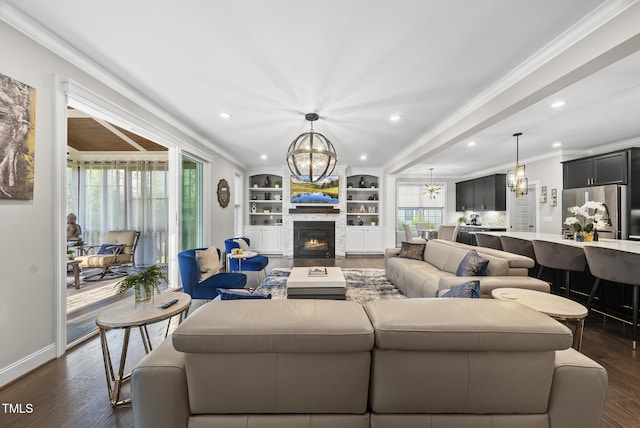 7741 Wilderness Rd, Raleigh, NC 27613 - living room featuring a chandelier, ornamental molding, recessed lighting, a warm lit fireplace, and dark wood-style flooring