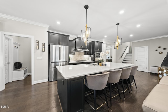 7741 Wilderness Rd, Raleigh, NC 27613 - kitchen featuring stainless steel refrigerator, light countertops, an island with sink, crown molding, and gas stovetop