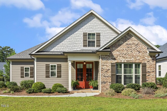 2461 Patriot Bluffs Dr, Fuquay Varina, NC 27526 - craftsman-style house with french doors, a front yard, brick siding, and roof with shingles