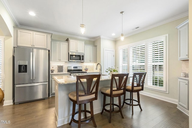 2461 Patriot Bluffs Dr, Fuquay Varina, NC 27526 - kitchen featuring appliances with stainless steel finishes, tasteful backsplash, ornamental molding, dark wood-style flooring, and light stone counters