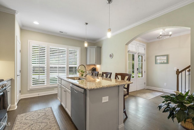 2461 Patriot Bluffs Dr, Fuquay Varina, NC 27526 - kitchen with appliances with stainless steel finishes, arched walkways, a kitchen bar, dark wood-type flooring, and a kitchen island with sink