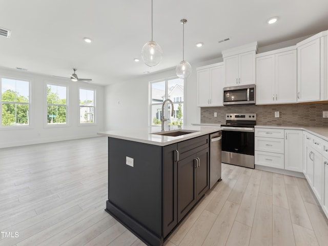 812 Barlow Dr Unit 255, Knightdale, NC 27545 - kitchen with appliances with stainless steel finishes, white cabinets, light countertops, light wood finished floors, and tasteful backsplash