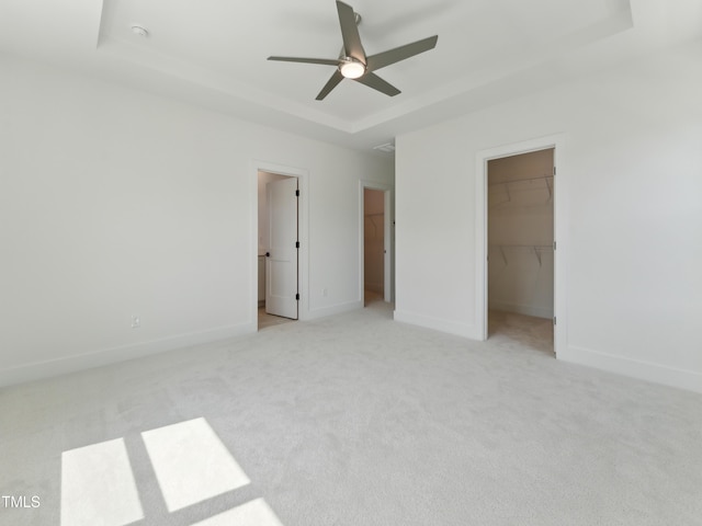 812 Barlow Dr Unit 255, Knightdale, NC 27545 - unfurnished bedroom with a spacious closet, a tray ceiling, carpet floors, a closet, and a ceiling fan