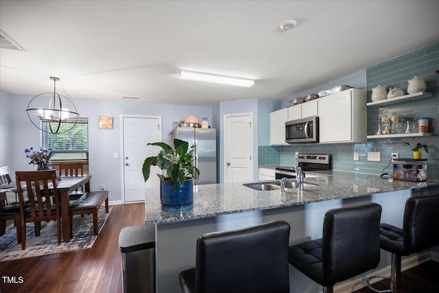 443 Waterfall Rd, Henderson, NC 27537 - kitchen with stainless steel appliances, a peninsula, stone countertops, backsplash, and white cabinets