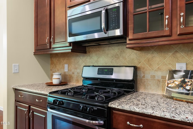508 Durants Neck Ln, Morrisville, NC 27560 - kitchen with stainless steel appliances, glass insert cabinets, decorative backsplash, and light stone countertops
