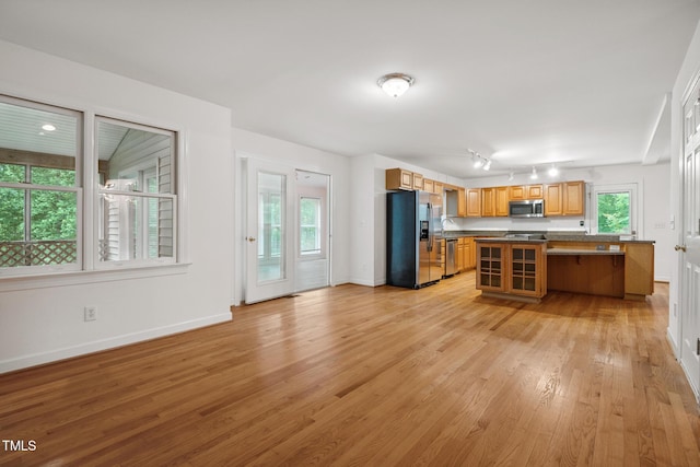 9903 Oak Hollow Rd, Chapel Hill, NC 27516 - kitchen with appliances with stainless steel finishes, dark countertops, light wood-style flooring, a kitchen breakfast bar, and open floor plan
