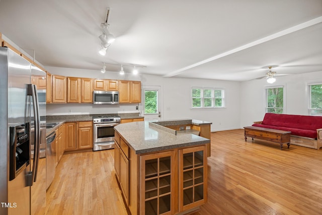 9903 Oak Hollow Rd, Chapel Hill, NC 27516 - kitchen featuring appliances with stainless steel finishes, light wood-style floors, a center island, open floor plan, and dark stone countertops