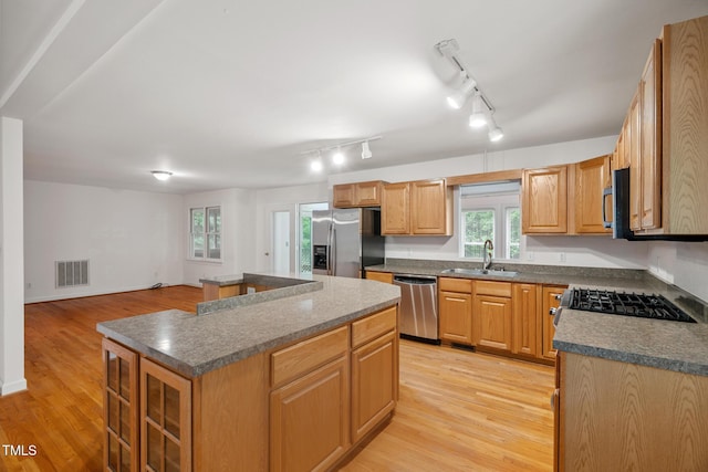 9903 Oak Hollow Rd, Chapel Hill, NC 27516 - kitchen with stainless steel appliances, dark countertops, a center island, and light wood-style flooring