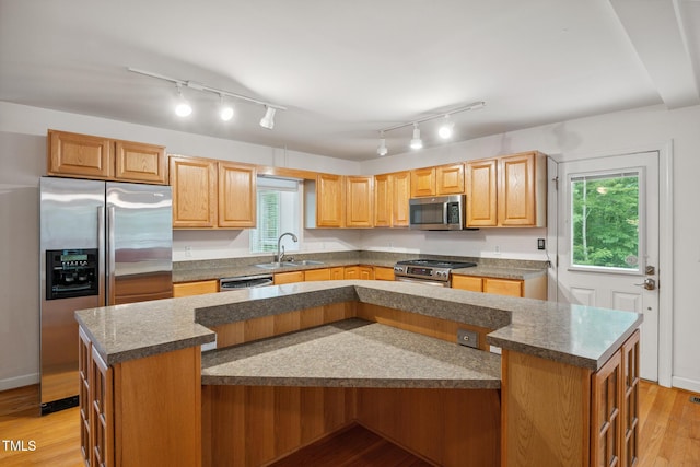 9903 Oak Hollow Rd, Chapel Hill, NC 27516 - kitchen with stainless steel appliances, a kitchen island, rail lighting, and light wood-style floors