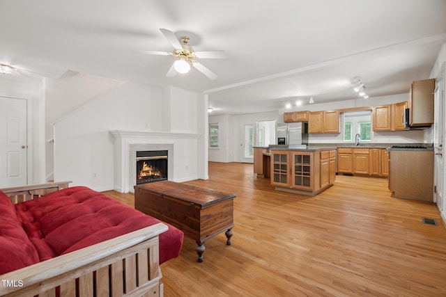 9903 Oak Hollow Rd, Chapel Hill, NC 27516 - living area featuring light wood-style floors, ceiling fan, and a warm lit fireplace