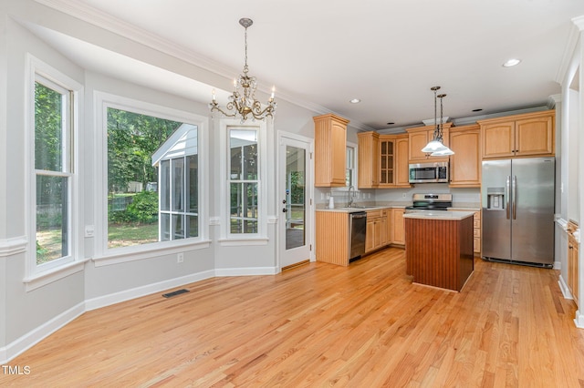106 Windstream Way, Cary, NC 27518 - kitchen featuring appliances with stainless steel finishes, light countertops, plenty of natural light, a center island, and ornamental molding