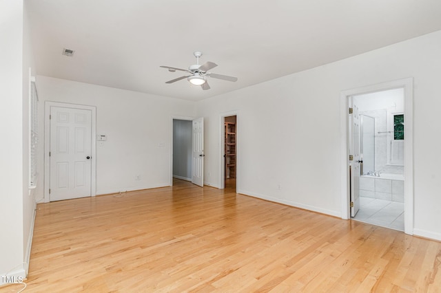 106 Windstream Way, Cary, NC 27518 - unfurnished bedroom with light wood-style flooring, a walk in closet, connected bathroom, a closet, and ceiling fan