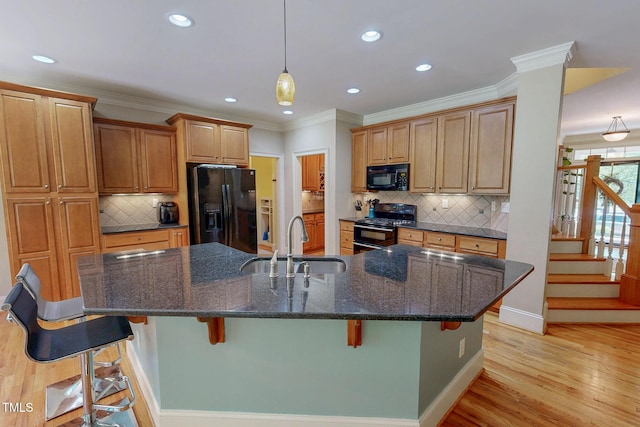 4 Springtree Cir, Durham, NC 27712 - kitchen featuring black appliances, a kitchen bar, light wood-style floors, recessed lighting, and pendant lighting