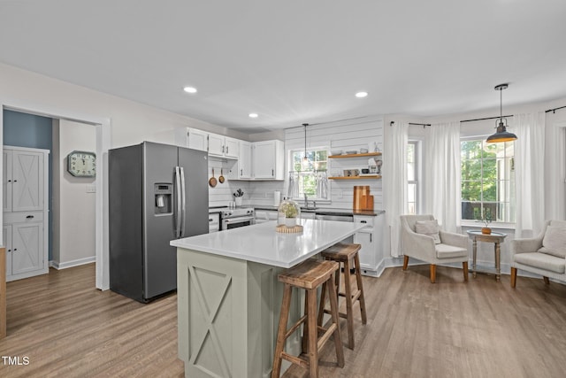 1604 Farm Lake Dr, Holly Springs, NC 27540 - kitchen with stainless steel appliances, light wood finished floors, healthy amount of natural light, a kitchen bar, and recessed lighting